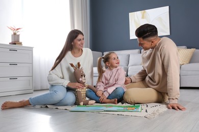 Photo of Happy family with little daughter spending time together at home. Floor heating concept