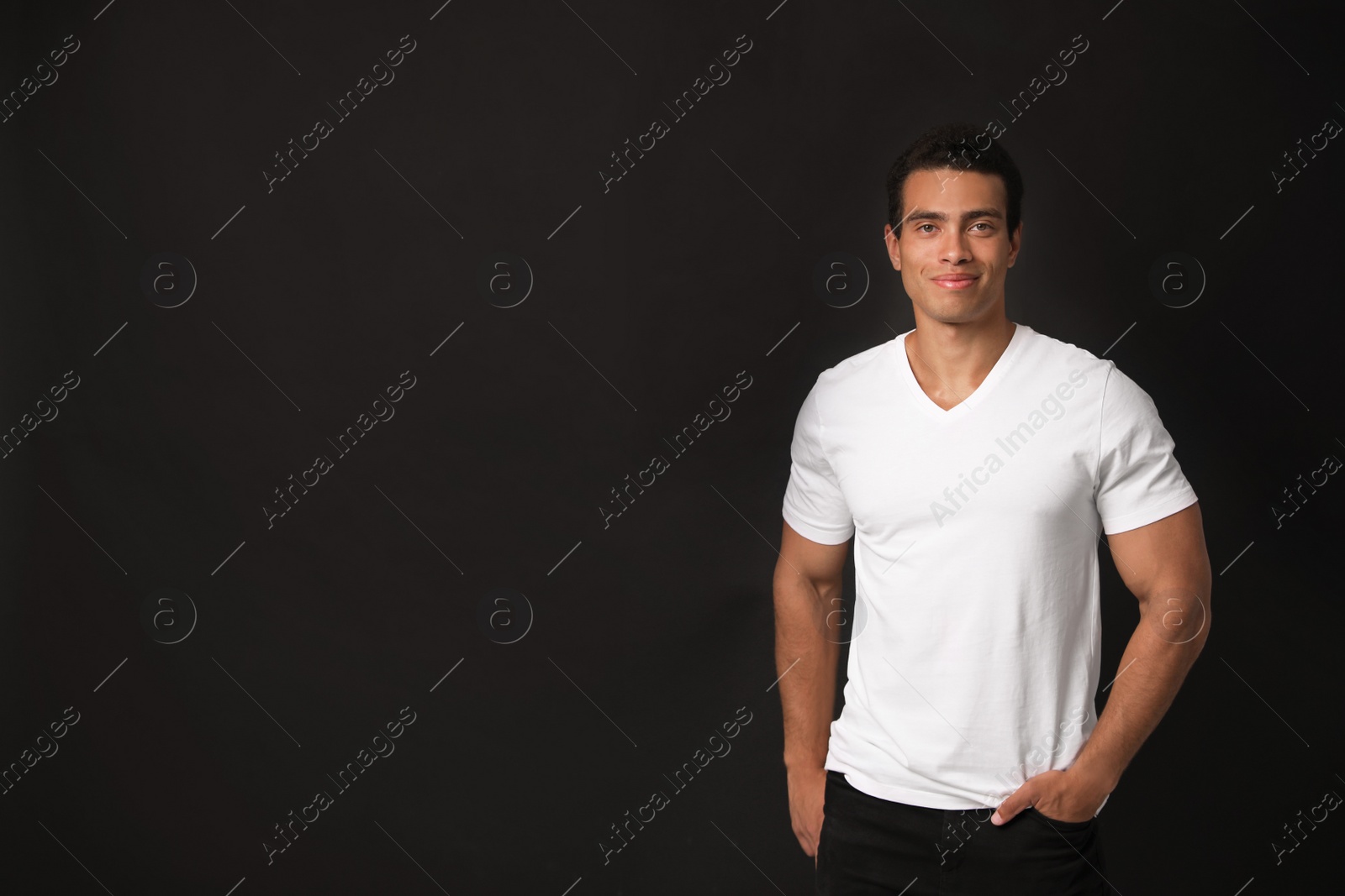 Photo of Handsome young African-American man on black background. Space for text