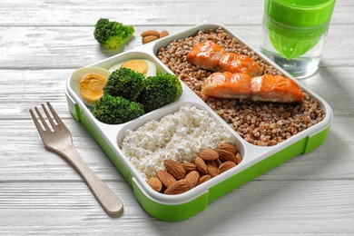 Container with natural healthy lunch and fork on table. High protein food