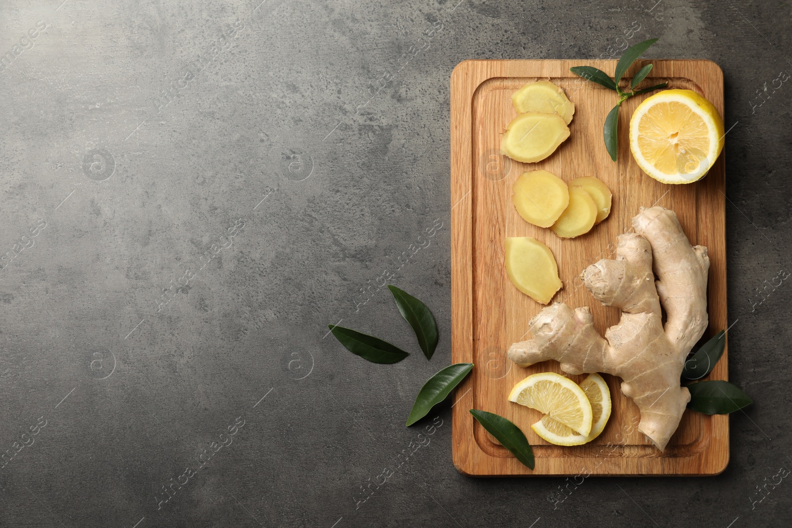 Photo of Fresh lemon and ginger on grey table, top view. Space for text