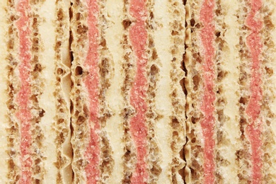 Photo of Wafer sticks with pink filling as background, closeup. Sweet food