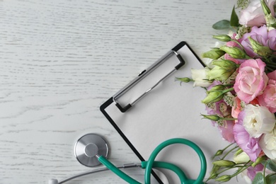 Photo of Flat lay composition with stethoscope and flowers on white wooden background, space for text. World health day