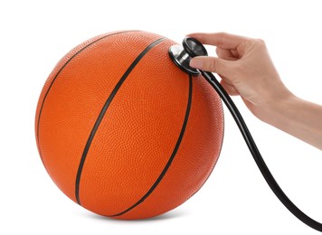 Doctor with stethoscope examining basketball ball on white background, closeup. Doping concept