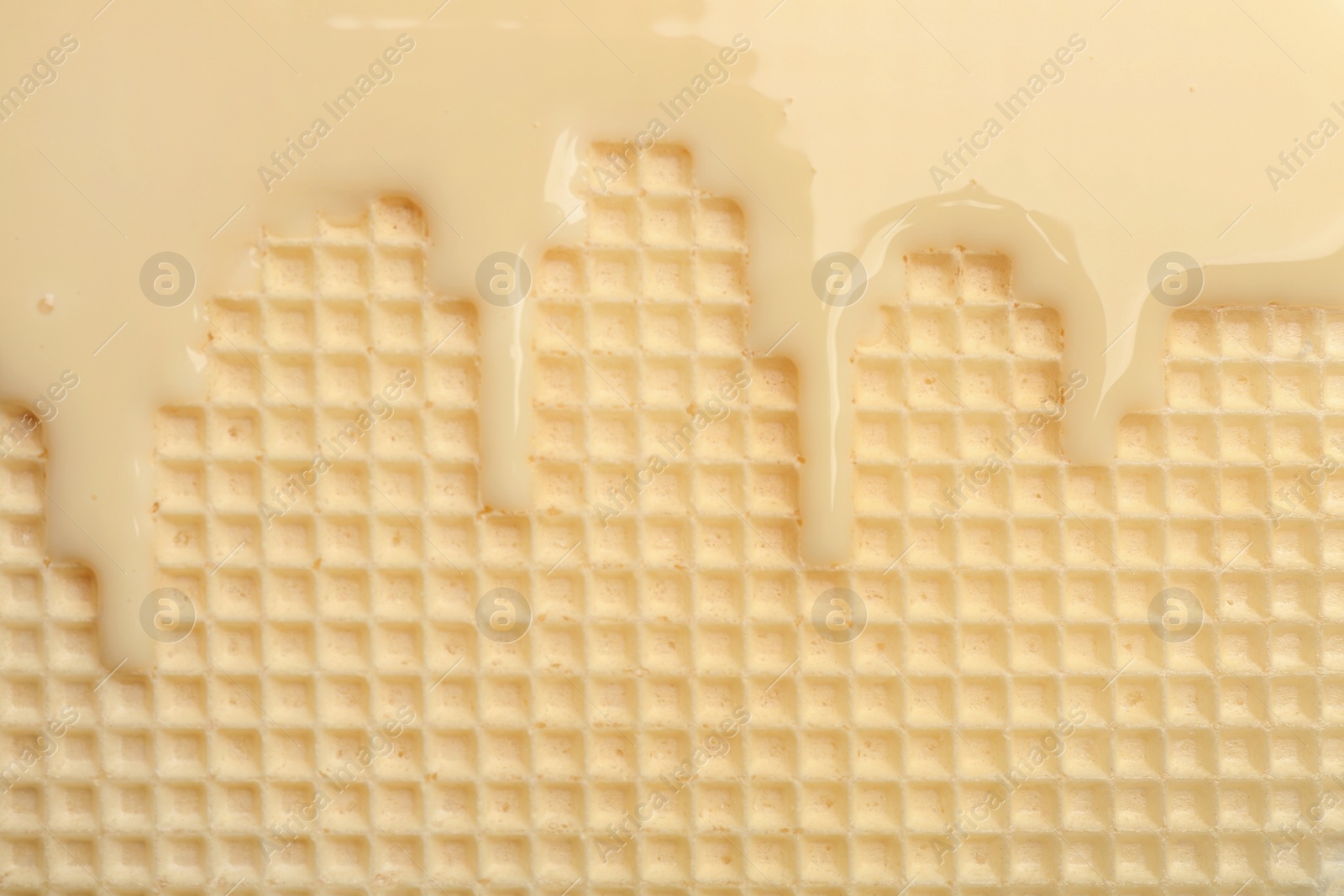 Photo of Hot white chocolate on wafer, closeup. Crispy food