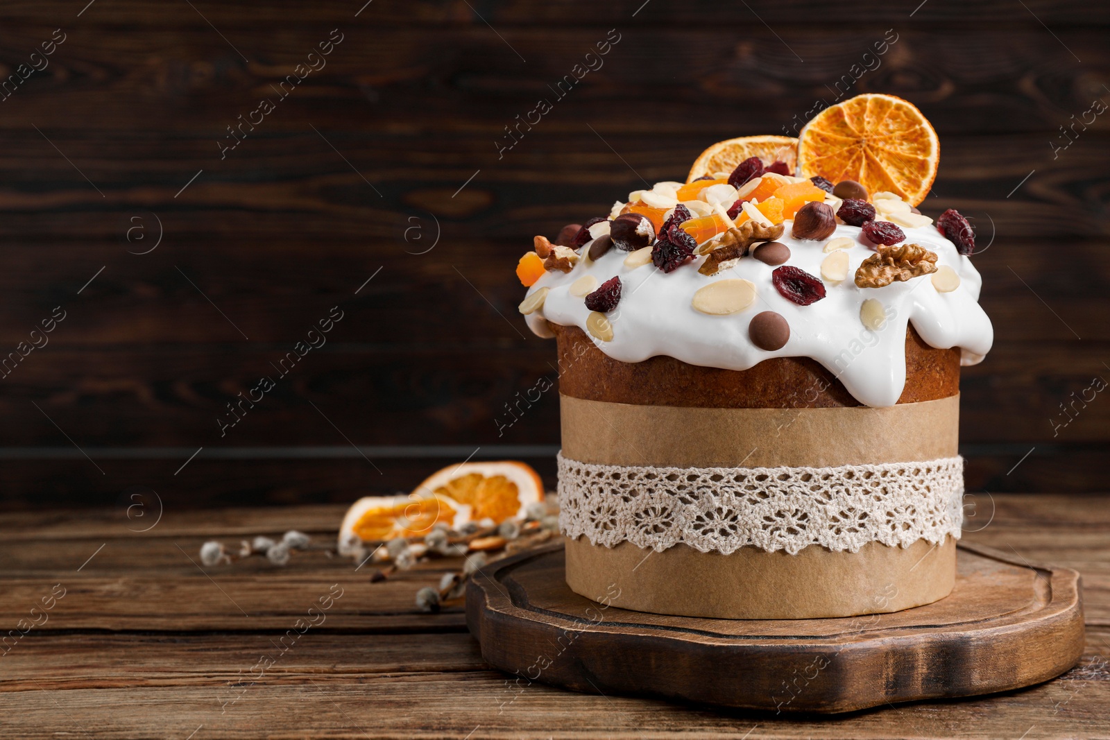 Photo of Delicious Easter cake with dried fruits and nuts on wooden table. Space for text