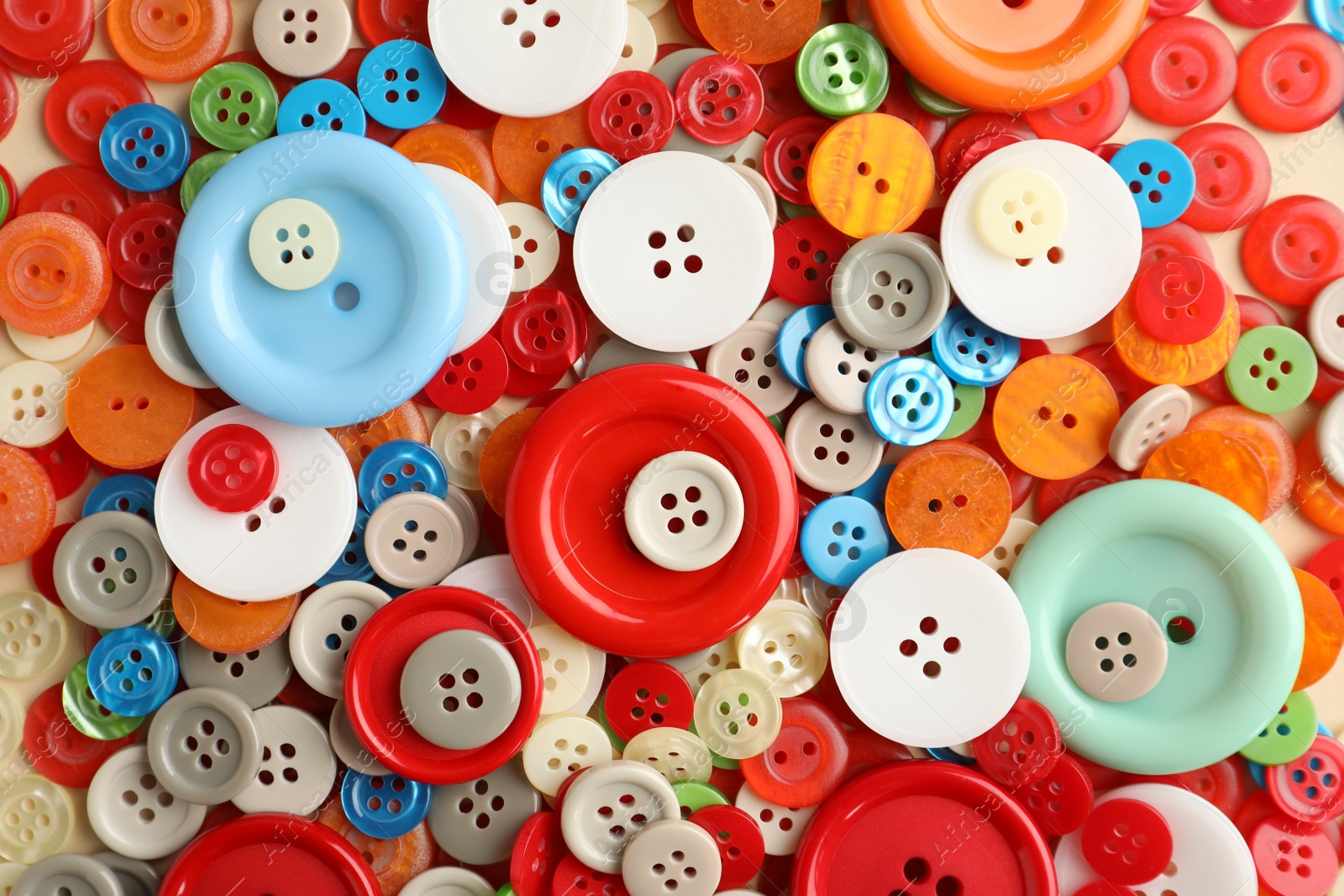 Photo of Many different sewing buttons on beige background, top view