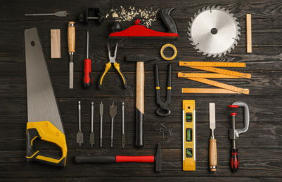 Flat lay composition with carpenter's tools on black wooden background