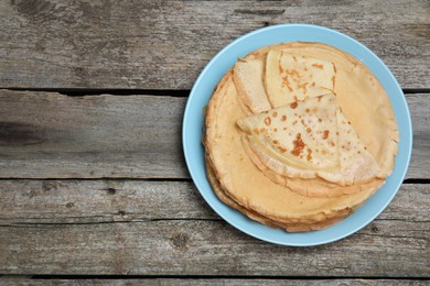 Photo of Delicious crepes on wooden table, top view. Space for text