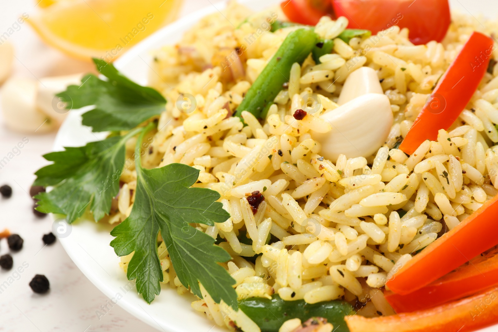 Photo of Tasty rice pilaf with vegetables on white table, closeup