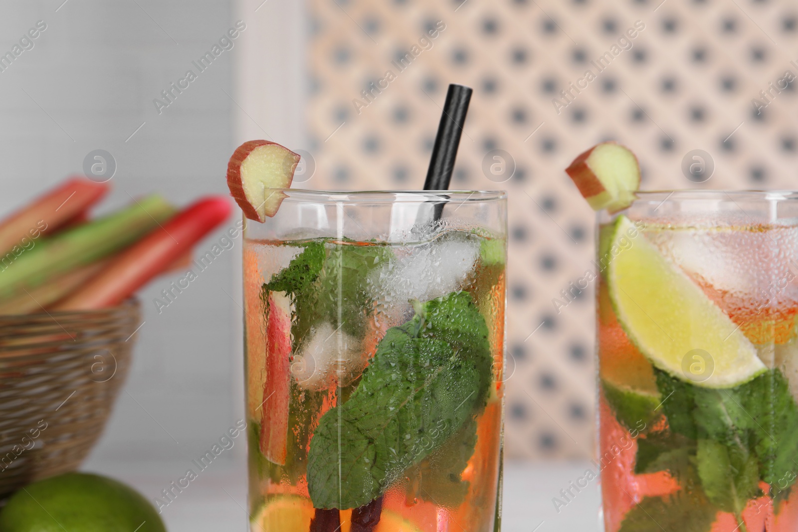 Photo of Tasty rhubarb cocktail with lime indoors, closeup