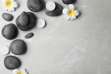 Photo of Flat lay composition with spa stones, candles and space for text on grey background