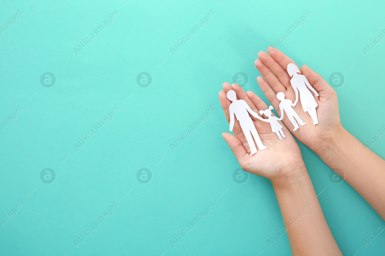 Photo of Woman holding paper family cutout on color background, top view