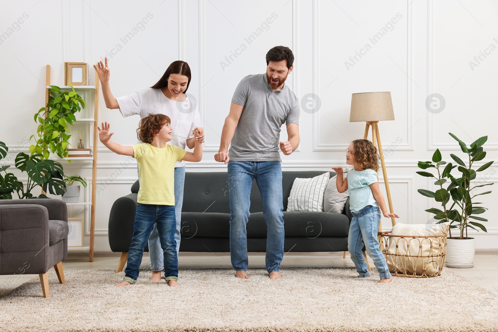 Photo of Happy family dancing and having fun in living room