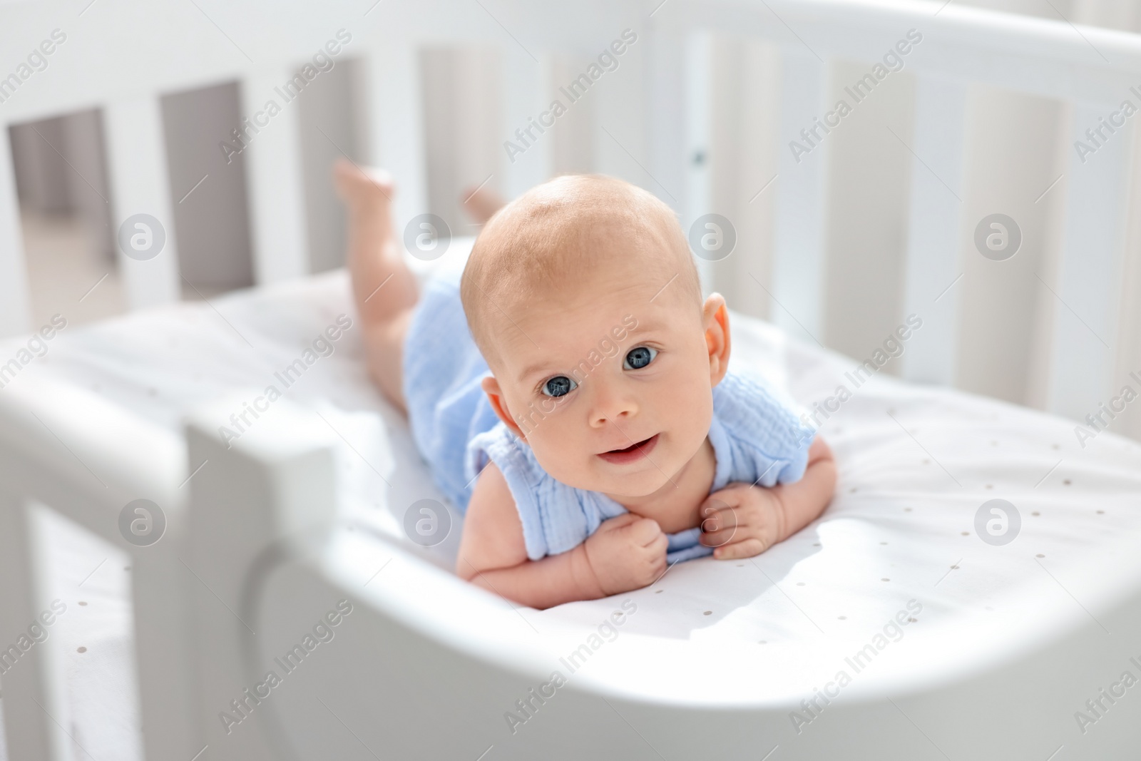 Photo of Cute little baby lying in crib at home