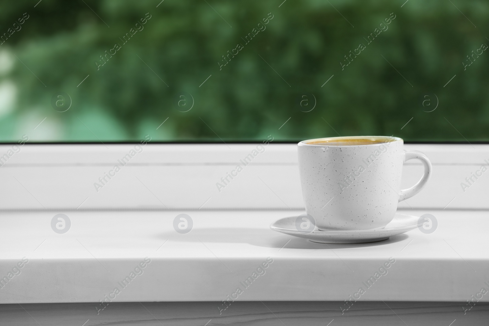 Photo of Cup of aromatic coffee on white sill near window indoors, space for text