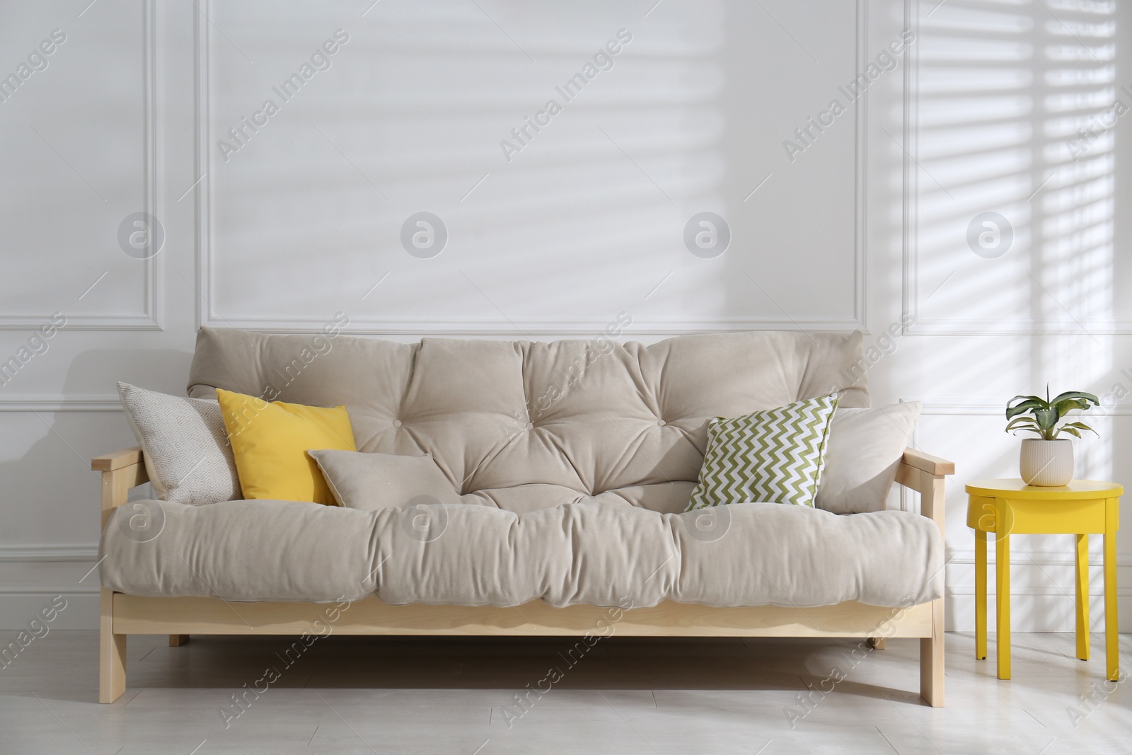 Photo of Stylish beige sofa in living room interior