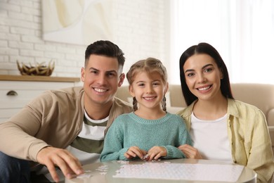 Happy family playing with puzzles at home