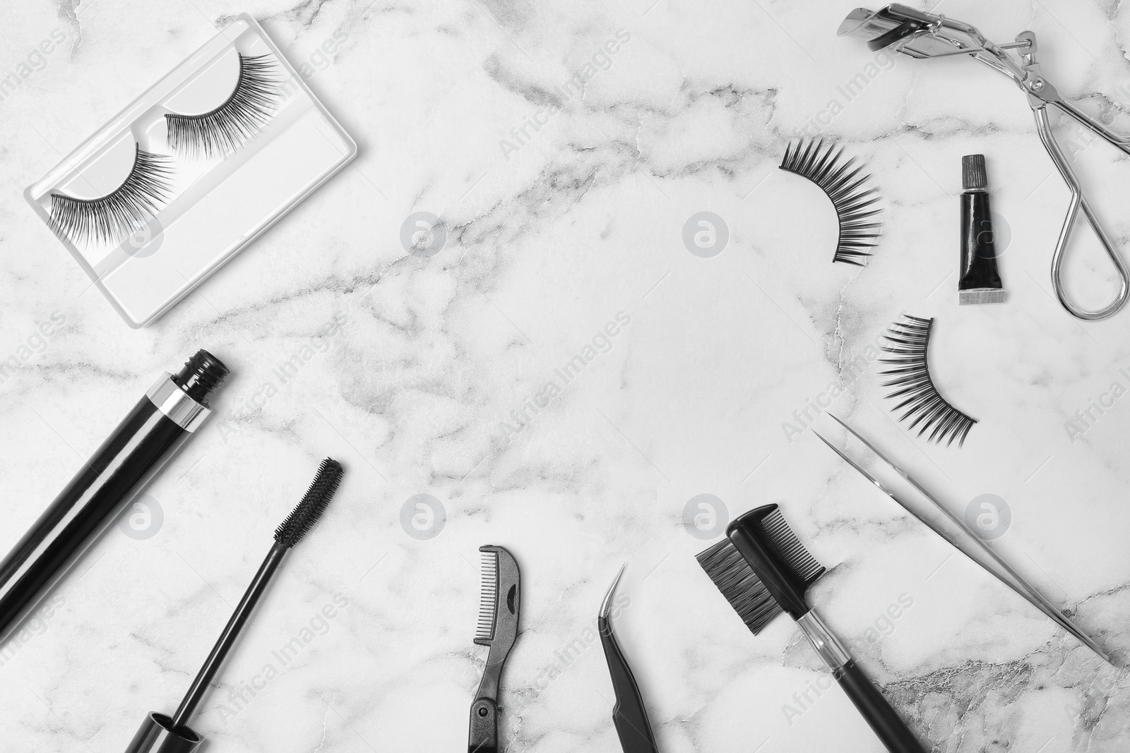 Photo of Flat lay composition with false eyelashes and cosmetic tools on light background