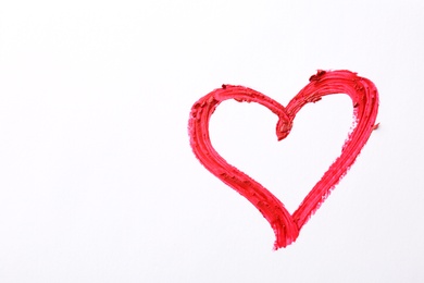 Heart drawn with red lipstick on white paper, top view