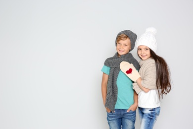 Photo of Cute little children in warm clothes posing on light background. Christmas celebration