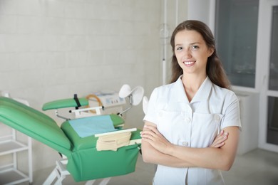 Photo of Portrait of smiling young gynecologist at workplace in clinic. Space for text