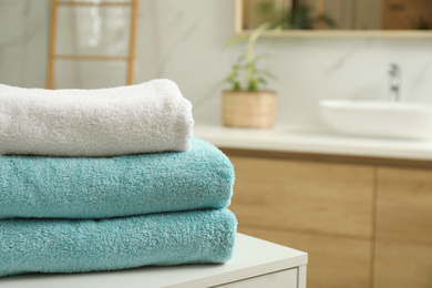 Photo of Stack of clean towels on table indoors. Space for text