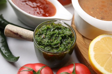 Photo of Different marinades in tableware on white table, closeup