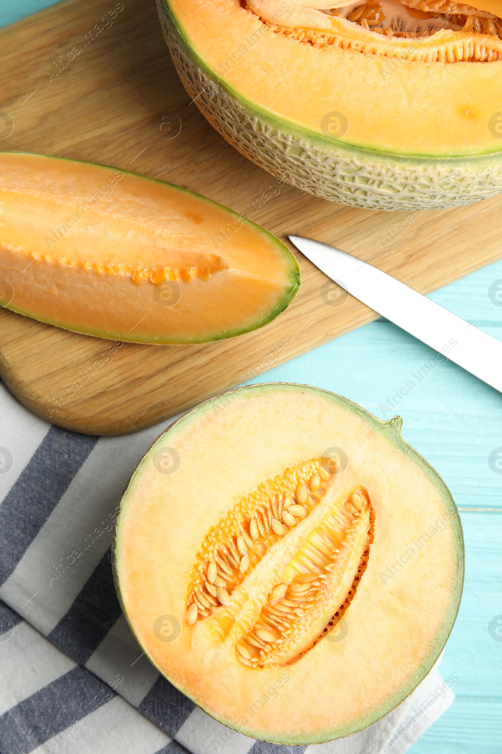 Photo of Tasty fresh melons on light blue wooden table, flat lay