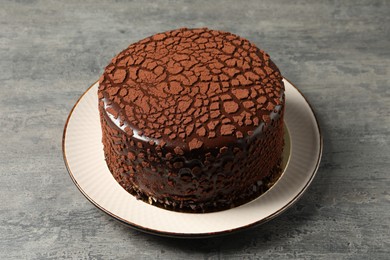 Photo of Delicious chocolate truffle cake on grey textured table
