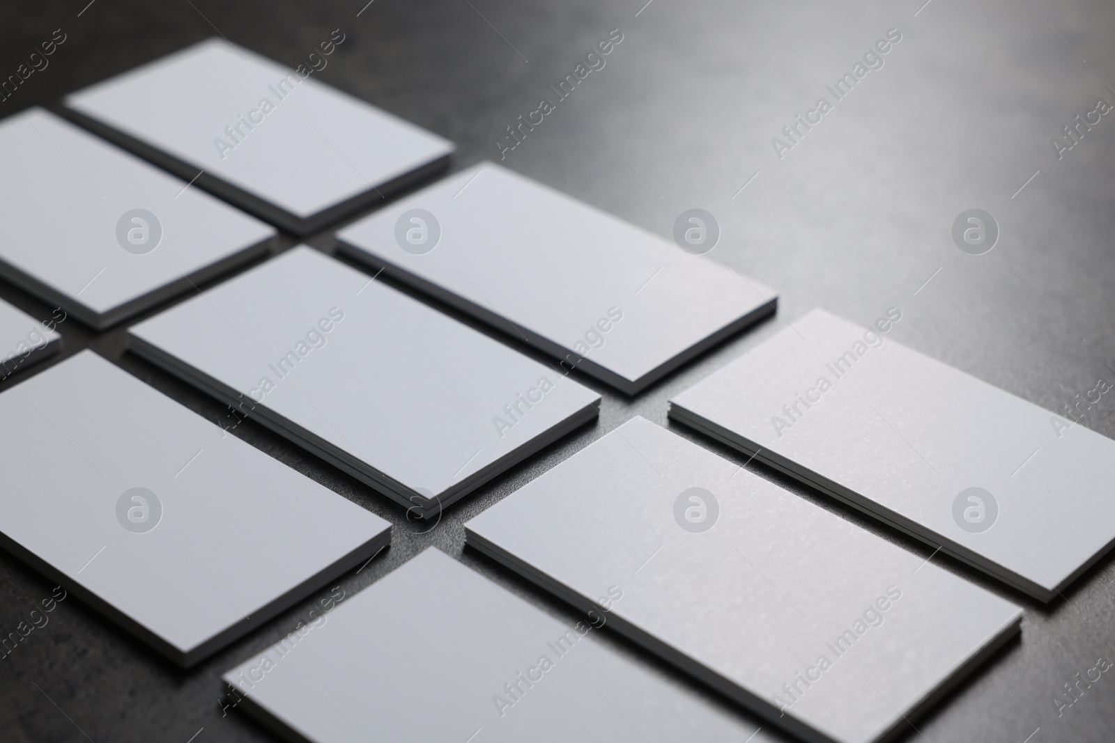 Photo of Blank business cards on grey textured table, closeup. Mockup for design