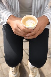 Coffee to go. Man with paper cup of drink outdoors, closeup