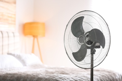 Photo of Modern electric fan in bedroom. Space for text