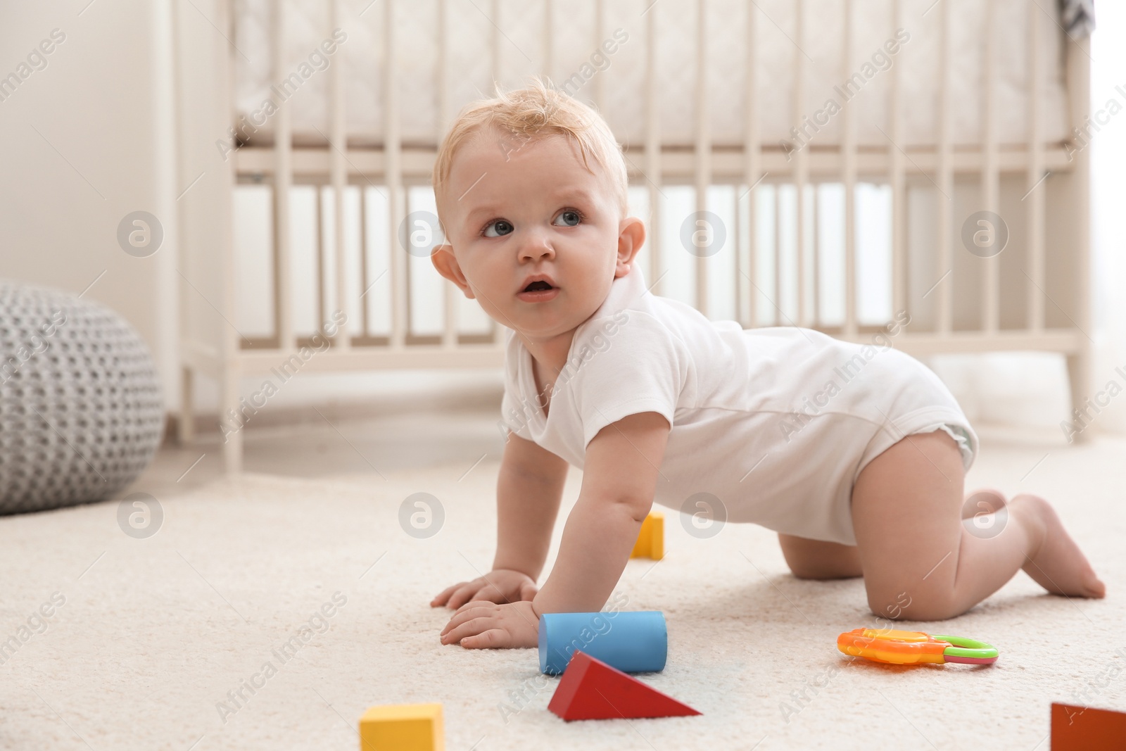Photo of Cute little baby crawling on carpet indoors
