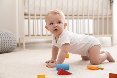 Cute little baby crawling on carpet indoors