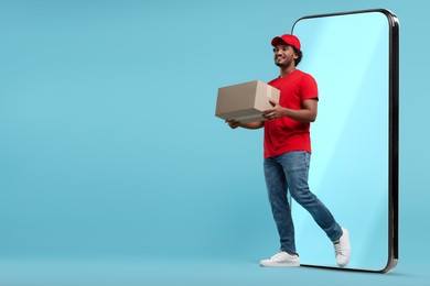 Courier with parcel walking out from huge smartphone on light blue background. Delivery service. Space for text