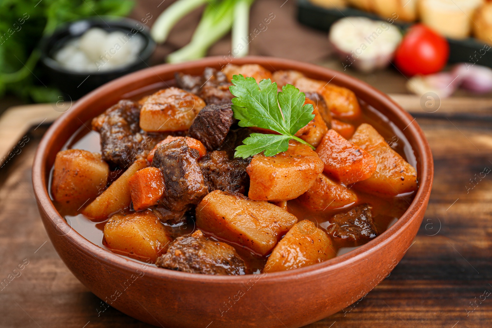 Photo of Delicious beef stew with carrots, parsley and potatoes, closeup