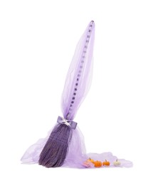 One beautiful witch's broom with tulle and decorative pumpkins isolated on white