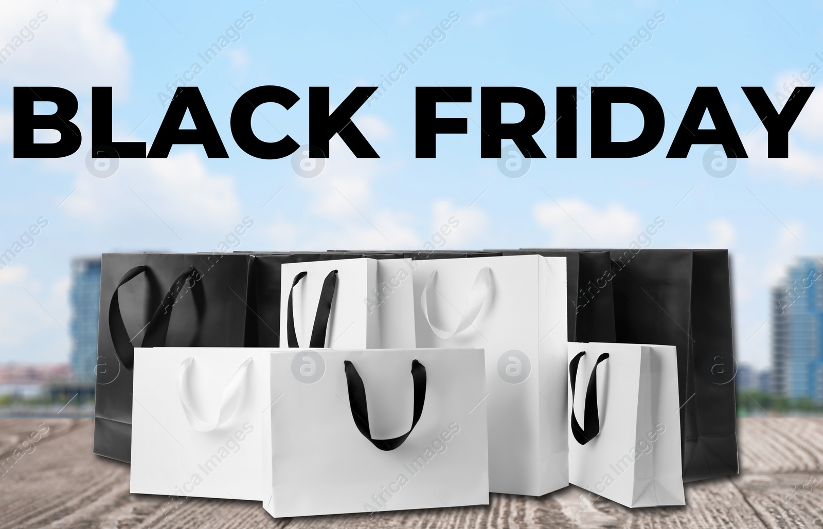 Image of Black Friday. Many shopping bags on wooden surface 