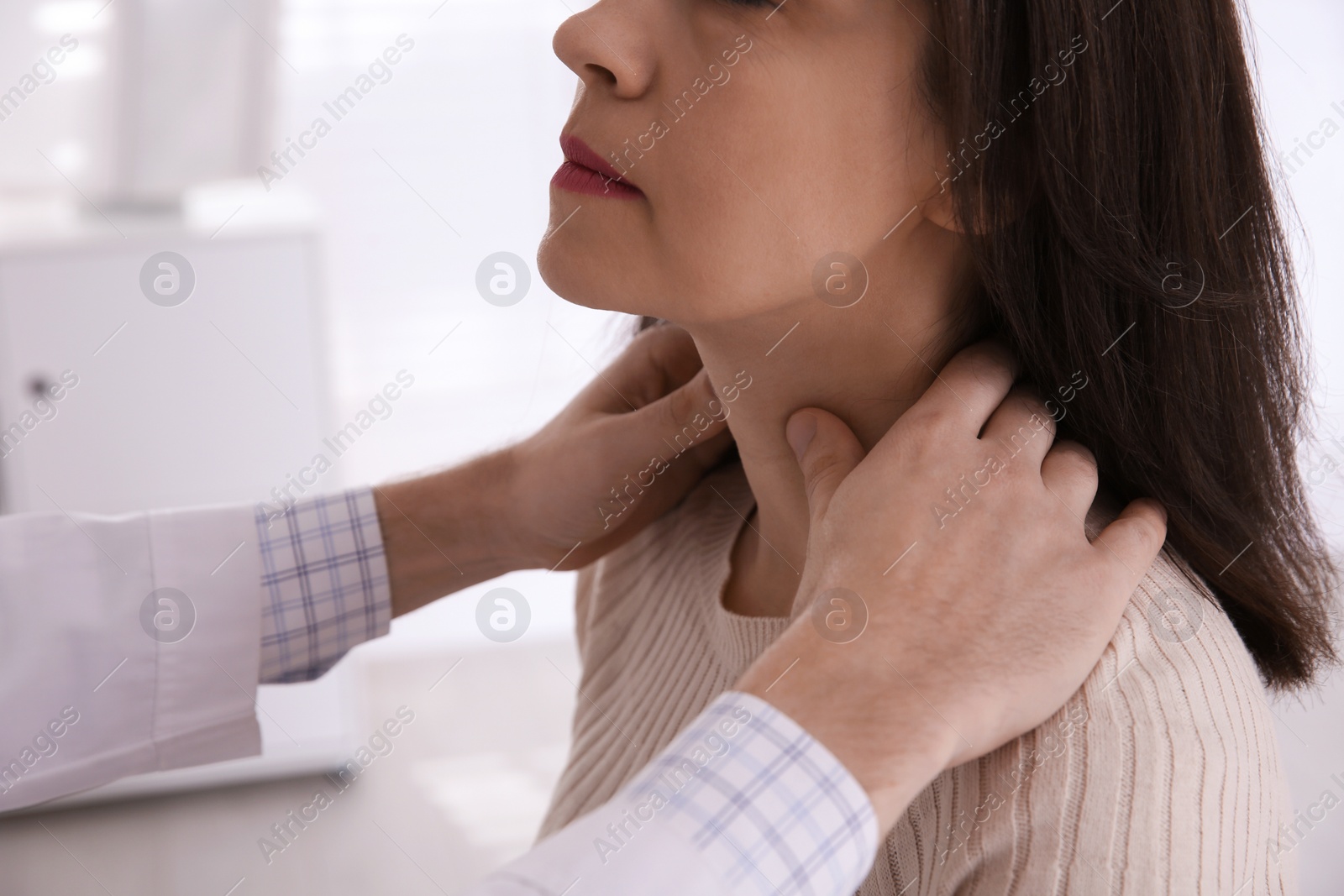 Photo of Doctor examining thyroid gland of patient in hospital, closeup