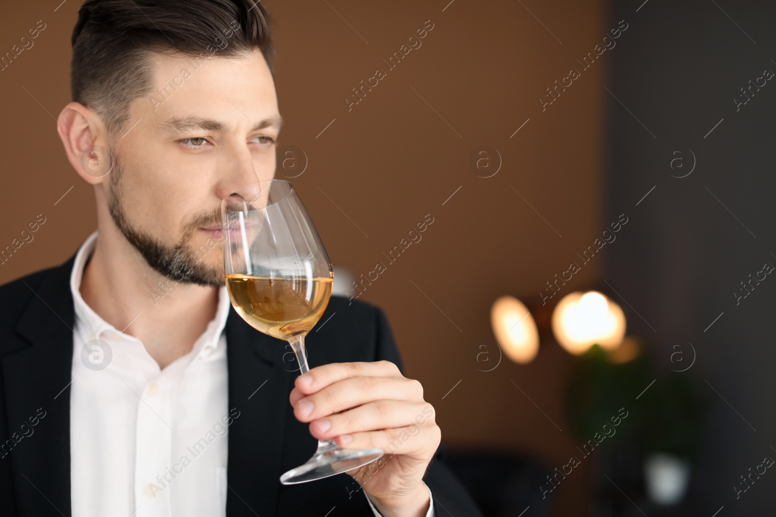 Photo of Young man with glass of wine indoors