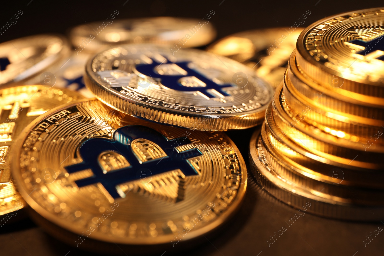 Photo of Shiny gold bitcoins on dark background, closeup view. Digital currency