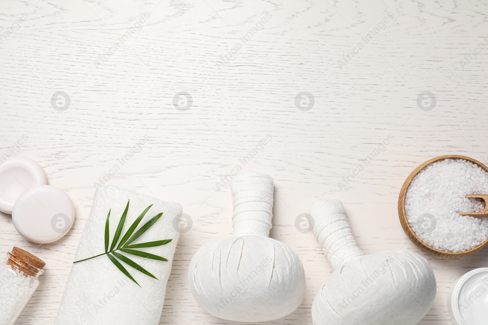 Photo of Flat lay composition of herbal bags and spa products on white wooden table, space for text