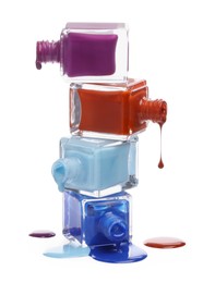 Photo of Color nail polishes dripping from bottles isolated on white