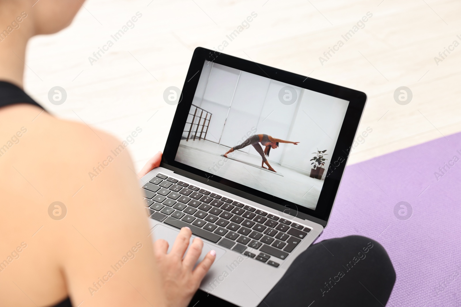 Photo of Online fitness trainer. Woman watching tutorial on laptop indoors, closeup