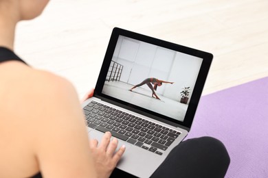 Online fitness trainer. Woman watching tutorial on laptop indoors, closeup