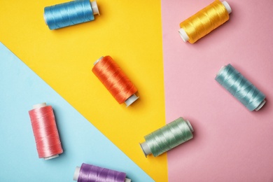 Photo of Flat lay composition with sewing threads on color background