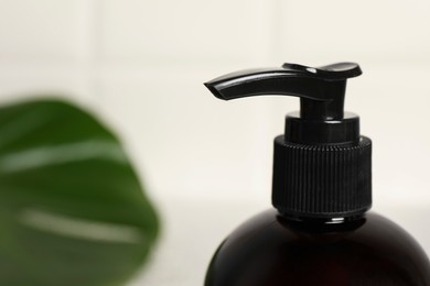 Photo of Shampoo bottle on blurred background, closeup. Space for text