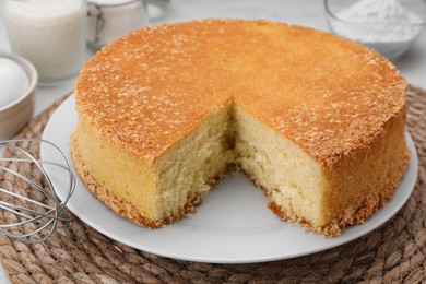 Cut tasty sponge cake on table, closeup