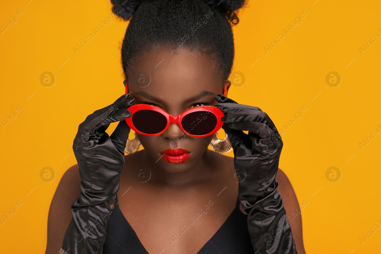 Photo of Fashionable portrait of beautiful woman with stylish sunglasses on yellow background