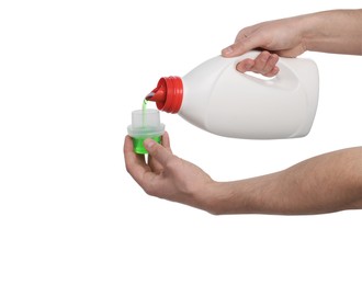 Man pouring fabric softener from bottle into cap for washing clothes on white background, closeup